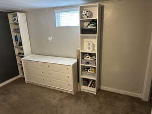 Bedroom with dark carpet and a textured wall