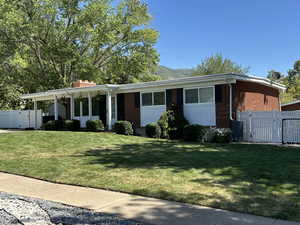 View of front facade with a gate, brick siding, a mountain view, and a chimney