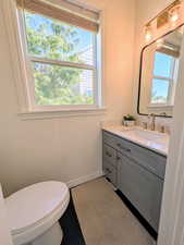 Half bathroom with vanity and dark tile patterned floors