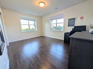 Living area featuring dark wood finished floors and a desk