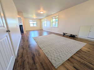 Living room with dark wood-style flooring and baseboards