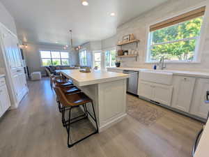 Kitchen featuring white cabinetry, light countertops, decorative backsplash, a center island, and recessed lighting
