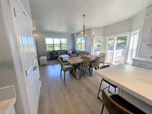 Dining area with healthy amount of natural light, light wood-style flooring, and a chandelier