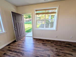 Entryway with dark wood-style flooring and baseboards