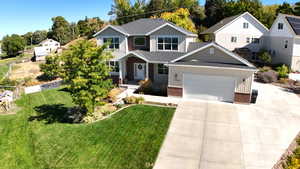 View of front of home featuring brick siding, concrete driveway, roof with shingles, and an attached garage