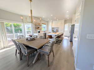 Dining room with arched walkways, recessed lighting, light wood-style floors, and a chandelier