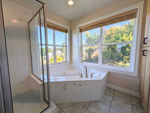 Bathroom featuring a stall shower, a garden tub, light tile patterned floors, and recessed lighting