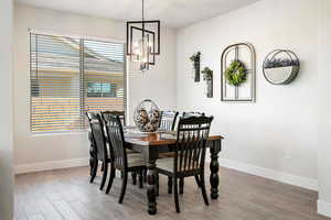 Dining room with light wood-type flooring and a chandelier