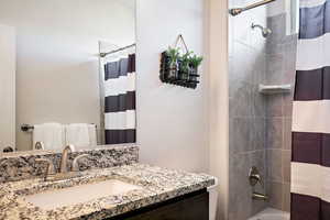 Full bathroom with shower / tub combo with curtain and vanity