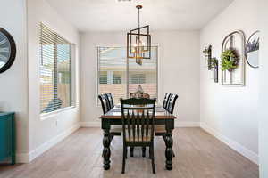 Dining room with light wood finished floors and a chandelier