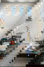 Living area with stairway, wood finished floors, and a high ceiling