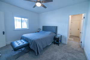 Carpeted bedroom featuring ceiling fan and baseboards