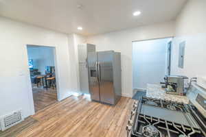 Kitchen featuring appliances with stainless steel finishes, light wood-style floors, recessed lighting, and electric panel