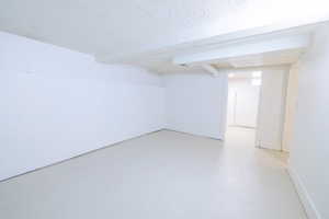 Finished below grade area featuring a textured ceiling