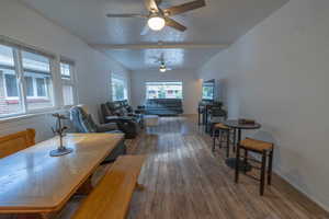Dining space with wood finished floors, a textured ceiling, ceiling fan, and beam ceiling