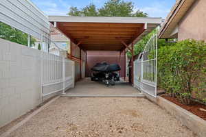 View of vehicle parking with a carport and driveway