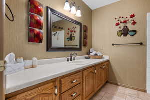 Full bathroom featuring vanity and stone tile floors