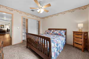 Bedroom with a closet, carpet, and a ceiling fan