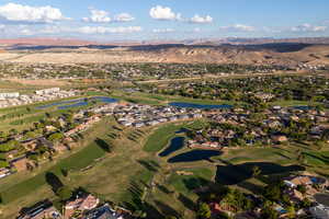 Aerial view of property's location featuring a water and mountain view, nearby suburban area, and a golf course