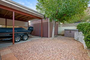 View of parking / parking lot featuring a fenced backyard and a storage unit