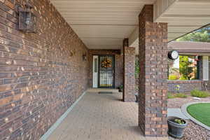 Property entrance with brick siding and a porch