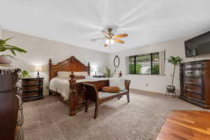 Bedroom with a textured ceiling, ceiling fan, light wood finished floors, and light carpet