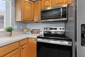 Kitchen featuring appliances with stainless steel finishes and solid surface countertop.