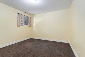 Carpeted empty room featuring baseboards