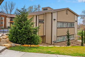 View of side of home with a shingled roof