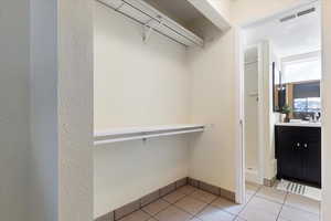 Spacious closet with light tile patterned floors