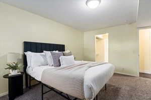 Bedroom with baseboards and dark carpet