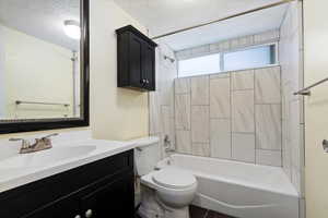 Full bath featuring shower / bath combination, vanity, and a textured ceiling