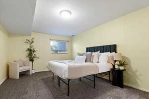 Bedroom featuring dark carpet and baseboards