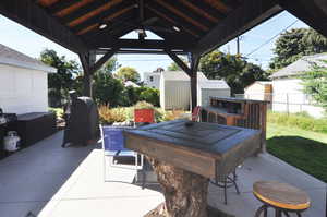 View of patio featuring a storage shed and area for grilling