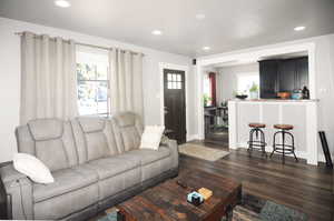 Living area featuring plenty of natural light, dark wood-style flooring, and recessed lighting