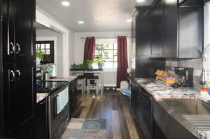 Kitchen with dark cabinetry, electric stove, dark wood-style floors, recessed lighting, and dishwasher