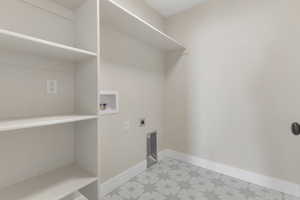 Laundry room with hookup for a washing machine, electric dryer hookup, and light flooring