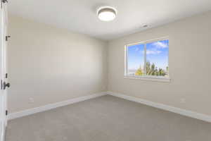 Empty room featuring baseboards and carpet
