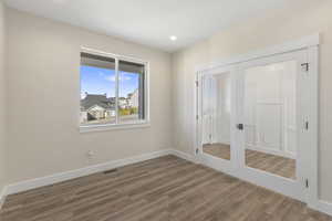 Spare room featuring french doors, wood finished floors, and recessed lighting