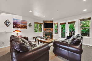 Living area featuring carpet, a fireplace, and recessed lighting