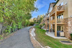 Surrounding community with a patio area and a lawn