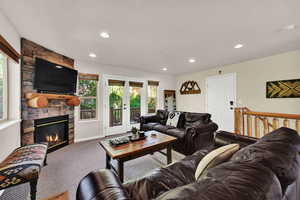 Living room with a fireplace, carpet floors, and recessed lighting