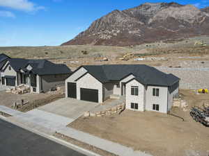 View of front facade with a mountain view, concrete driveway, and an attached garage