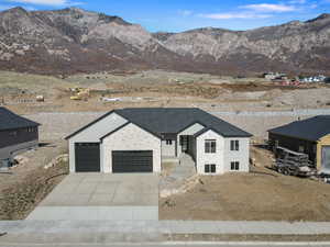 View of front of home with a mountain view, driveway, and an attached garage