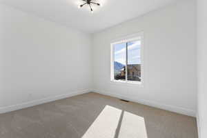 Carpeted empty room featuring baseboards and a mountain view