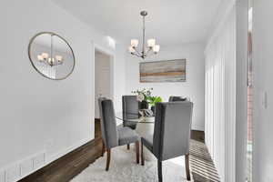 Dining space featuring a chandelier and wood finished floors