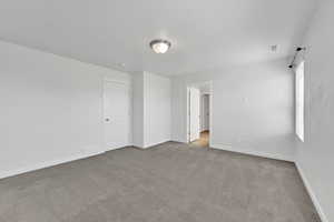 Spare room with light colored carpet and baseboards