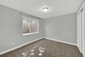 Unfurnished bedroom with a closet, carpet, and a textured ceiling