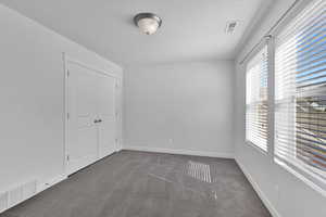 Unfurnished bedroom with carpet floors, a textured ceiling, and a closet