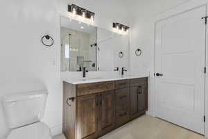Bathroom featuring a stall shower, double vanity, and light tile patterned floors